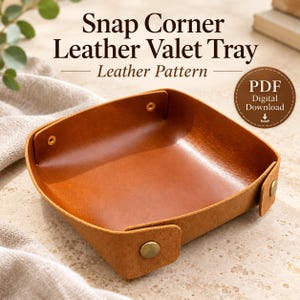 May include: A tan leather valet tray with snap corners and metal fasteners. The text reads: Snap Corner Leather Valet Tray, Leather Pattern, PDF Digital Download. The tray has a smooth interior and a textured exterior finish.