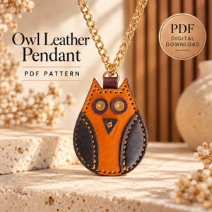 May include: An owl-shaped leather pendant hanging from a gold-toned chain. The pendant features orange and dark brown leather pieces stitched together with visible thread, and includes the text Owl Leather Pendant PDF PATTERN.