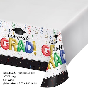 May include: White plastic tablecloth with a black border. The tablecloth features a graduation theme with colorful balloons spelling "Congrats Grad!" and confetti. The tablecloth measures 102 inches long and 54 inches wide. It is pictured on a 30 inch by 72 inch table.