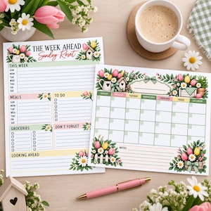 May include: Two printed paper planners featuring floral illustrations of pink and yellow tulips and white daisies. One planner is a weekly organizer with sections for meals, groceries, and to-do lists. The other is a monthly calendar grid.
