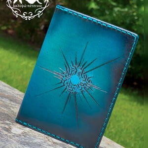 May include: A teal leather wallet with a starburst design and teal stitching. The wallet has a gradient effect, transitioning from a darker teal to a lighter shade. The Calypso Corium logo is visible in the upper left corner.