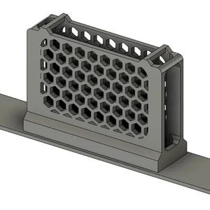 May include: A gray, rectangular storage holder featuring a distinct honeycomb pattern on its side walls. The structure includes a flat, elongated base plate with mounting holes at each end, designed for secure attachment to a flat surface.