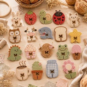 Puede incluir: Una colección de diecinueve parches bordados con diversos diseños, incluyendo un conejo, fresa, caracol, mariquita, gato, búho, vaca, tiburón, rebanada de pan, estrella, dinosaurio, cupcake, vaca highland, rana, helado, taza de café, cactus, frasco y flor.