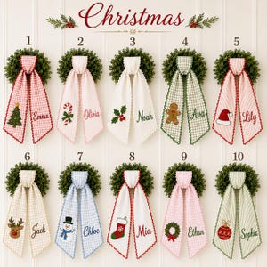 Puede incluir: Diez coronas navideñas decorativas con largas cintas de tela colgantes con bordes festoneados. Cada cinta muestra un icono festivo bordado único y un nombre personalizado, incluyendo Emma, Olivia, Noah, Ava, Lily, Jack, Chloe, Mia, Ethan y Sophia.