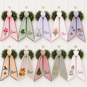 Puede incluir: Diez colgadores decorativos para puertas con coronas de boj verde rematadas con largas cintas de tela estampadas. Cada cinta está bordada con diseños estacionales únicos y nombres como Emma, Liam, Olivia, Mom, Ava, Mason, Harper, Noah, Chloe y Emily.