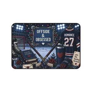 May include: A rectangular mat featuring a hockey-themed illustration with the text "OFFSIDE & OBSESSED" in a decorative frame, a jersey with "ROMANCE 27", two crossed hockey sticks, a book titled "LOVE STORY", a tumbler, a glove, and a note.