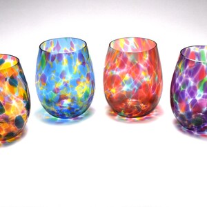 May include: Six colorful glass tumblers with a speckled pattern. Each tumbler has a different color base with a mix of colorful speckles.