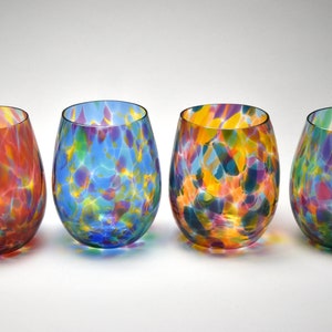May include: Set of four colorful glass wine glasses with a speckled pattern. Each glass has a different color base, including red, blue, yellow, and green.
