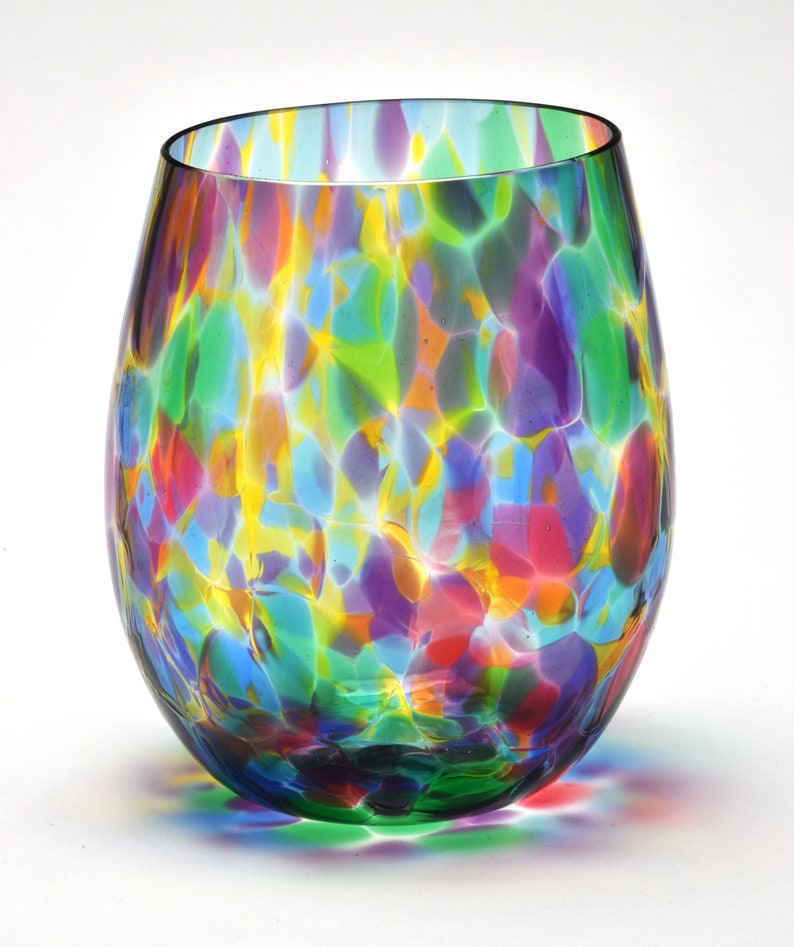 May include: A colorful glass wine glass with a speckled pattern in shades of green, blue, yellow, purple, and red.