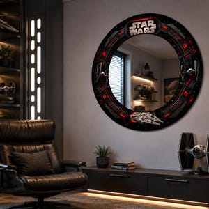 May include: A circular wall mirror featuring a black frame decorated with Star Wars graphics, including the Millennium Falcon, TIE fighters, and red light accents. The top of the frame displays the Star Wars logo in silver lettering.