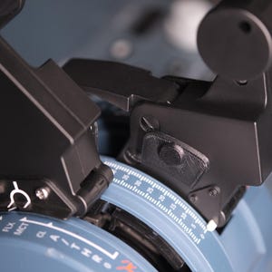 May include: A flight simulator throttle quadrant featuring two black levers with textured grips and a red button. The base is light blue with white printed markings including TO, GA, FLX, MCT, and a numerical scale ranging from 0 to 30.