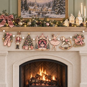 May include: A Christmas garland featuring six hanging ornaments on a string with white pom-poms. The ornaments include pink ballet slippers, a nutcracker, a decorated tree, a castle, a ballerina, a rocking horse, and a gift-filled sleigh.