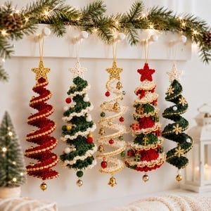 May include: Five spiral-shaped crochet Christmas tree ornaments hanging from a white rack. The trees are decorated with small beads, bells, and miniature gift boxes, each topped with a crocheted star. The colors include red, green, and cream.
