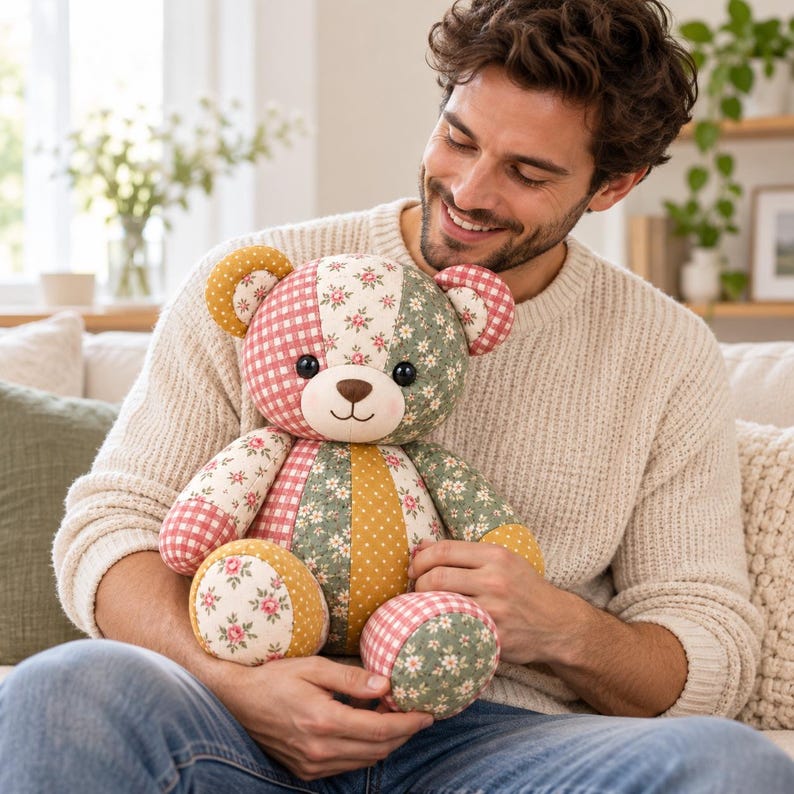 Pode incluir: Um urso de peluche de patchwork feito com v&aacute;rios padr&otilde;es de tecido, incluindo xadrez vichy vermelho e branco, estampados florais verdes e bolinhas amarelo-mostarda. O urso tem olhos redondos escuros, nariz bordado e boca sorridente.