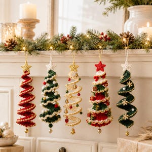 May include: Five spiral-shaped crochet Christmas tree ornaments hanging in a row. Each tree features a small crocheted star at the top and various embellishments including miniature bells, tiny gift boxes, white pom-poms, and gold snowflakes.
