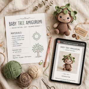 Könnte beinhalten: Eine gehäkelte Baby-Baum-Amigurumi-Puppe, ein gedrucktes Anleitungsblatt mit dem Titel Baby Tree Amigurumi, ein Tablet mit derselben Anleitung, eine kupferfarbene Häkelnadel, drei Garnknäuel in Grün, Braun und Creme sowie kleine Maschenmarkierer.