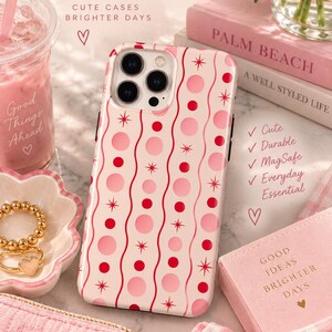 May include: A phone case with a light pink background featuring a pattern of vertical wavy lines, red and pink circles, and small starburst icons. The text on the image reads Preppy Phone Cases, Cute Cases Brighter Days, Good Things Ahead, Good Ideas Brighter Days, and Preppy Days.