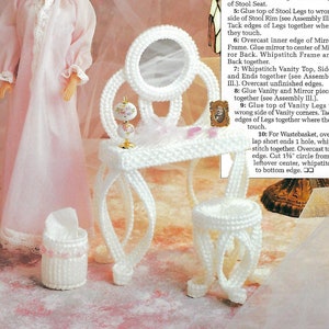 May include: A white plastic canvas vanity set with a mirror, stool, and wastebasket. The vanity is 2 inches by 4 1/2 inches by 8 1/4 inches tall. The stool is 2 1/2 inches tall. The set is made with 7-mesh plastic canvas and white worsted-weight yarn.