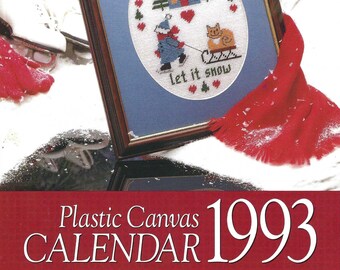 May include: A plastic canvas calendar for 1993 with a winter scene featuring a house, trees, a cat, and a person pulling a sled. The text "Let it snow" is included in the design.