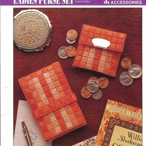 May include: An orange and white checkered purse set with a matching compact mirror and coins. The set includes a small wallet with a silver clasp and a larger case. The text "LADIES PURSE SET" is at the top.