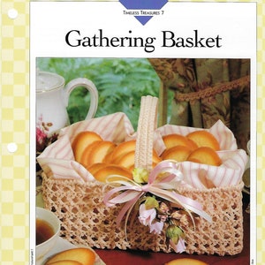 May include: A crocheted basket with a pink and white striped lining, filled with cookies and decorated with a pink ribbon and flowers. The basket is a classic Shaker-style design.