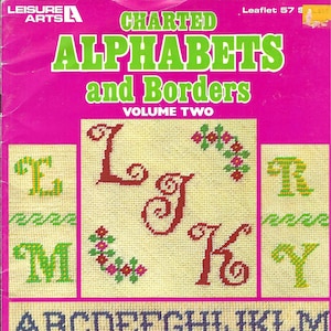 May include: A cross-stitch pattern booklet titled "Charted Alphabets and Borders, Volume Two" with a pink cover and a variety of colorful cross-stitch designs for letters and borders.