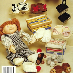 May include: An assortment of handmade baby shoes and accessories, including booties, sandals, and boxes. The shoes are in various colors, such as white, brown, and red. A doll is also present, wearing a striped dress.