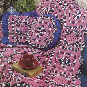 May include: A pink, white, and blue crocheted afghan set with a throw and two pillows. The set features a diamond pattern and is called "Raspberry Diamonds Afghan Set".