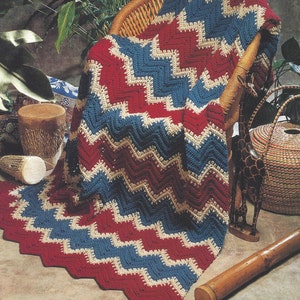 May include: A crochet pattern for a red, white, and blue chevron afghan. The pattern is called "Kenya Ripple" and is part of the "Collector's Series".