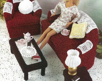 May include: A crocheted dollhouse living room set with a red couch, armchair, coffee table, and end table. The set includes crocheted pillows, a lampshade, and doilies. The text "Contemporary Living Room" is visible in the image.