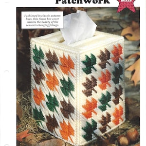 May include: A white tissue box cover with a patchwork design of orange, green, and brown leaves. The text "Autumn Patchwork" is at the top of the image. The text "Tissue Boxes" is in a red star shape.