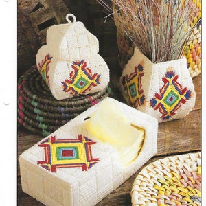 May include: A set of three white plastic canvas tissue box covers with colorful geometric designs. The designs are inspired by the Ojo de Dios, a traditional Mexican craft. The covers are decorated with red, yellow, blue, and green yarn.