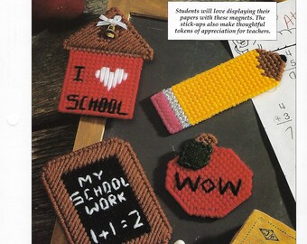 May include: Four felt magnets with school themes. A red schoolhouse with "I love school" on it, a yellow pencil, a red apple with "Wow" on it, and a brown chalkboard with "My School Work 1+1=2" on it.