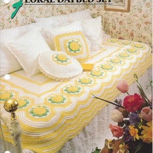 May include: A crocheted floral daybed set in white and yellow with a green center. The set includes a bedspread, two pillows, and a throw pillow.