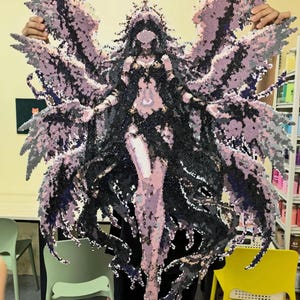 May include: A large pixel art wall hanging featuring a central figure with expansive, detailed wings in shades of black, purple, and light pink. The figure has long dark hair, a crown, and flowing dark garments, constructed from small square beads.