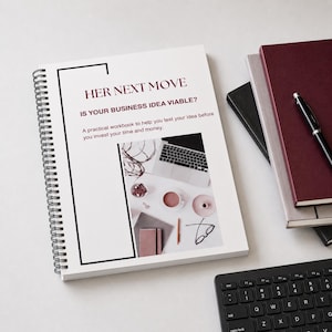 Op de afbeelding: Een spiraalgebonden werkboek met de titel HER NEXT MOVE IS YOUR BUSINESS IDEA VIABLE? A practical workbook to help you test your idea before you invest your time and money. De omslag bevat een foto van een laptop, koffie en schrijfwaren.