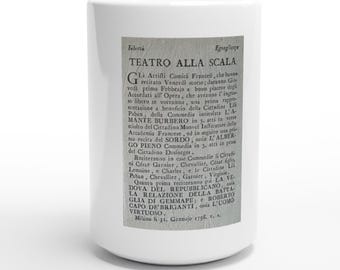 May include: A white ceramic mug featuring a rectangular black and white print of a historical document titled Teatro alla Scala, dated January 31, 1798. The text details theatrical performances and lists various actors and play titles in Italian.