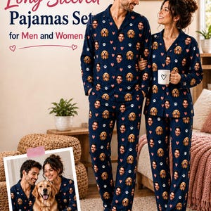 Op de afbeelding: Een bijpassende pyjamaset met lange mouwen in marineblauw met een herhalend patroon van een menselijk gezicht, een golden retriever-gezicht, witte pootafdrukken en kleine rode hartjes. De set bestaat uit overhemden met kraag en lange broeken.