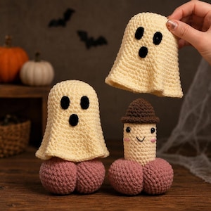 May include: Three crocheted figures: two cream-colored ghosts with black felt eyes and mouths, and one cream-colored figure wearing a brown hat with a smiling face and pink cheeks. All figures feature rounded, textured pink bases made of yarn.