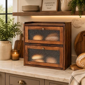 May include: A two-tier wooden bread box with a dark brown finish, featuring two drop-down doors with textured, semi-opaque glass panels and small round metal knobs. The unit is rectangular and designed for countertop storage of baked goods.
