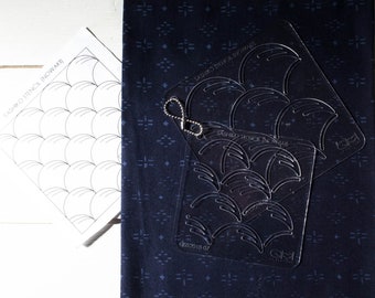 May include: A navy blue fabric with a repeating pattern is paired with clear plastic stencils for sashiko embroidery. The stencils are labeled "Sashiko Stencil (Nowaki)" and feature a curved design. A printed template is also included.