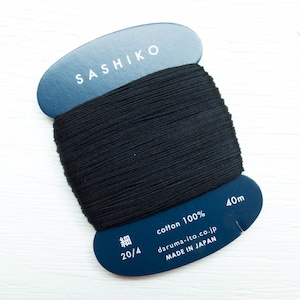 May include: A spool of black Sashiko cotton thread, 100% cotton, 40m. The label is dark blue with white text, including "SASHIKO" and "20/4". Made in Japan.
