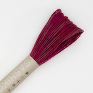 May include: A bundle of Sashiko thread in shades of red and burgundy. The thread is wrapped in a paper label with Japanese text. The thread is approximately 20 metres in length.