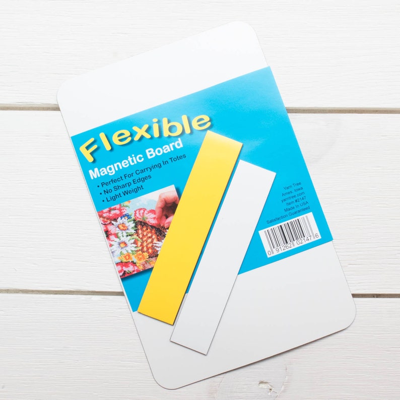 May include: A white flexible magnetic board with a blue and yellow label. The label reads "Flexible Magnetic Board" and includes the text "Perfect For Carrying In Totes, No Sharp Edges, Light Weight". Two rectangular magnets, one yellow and one white, are included.