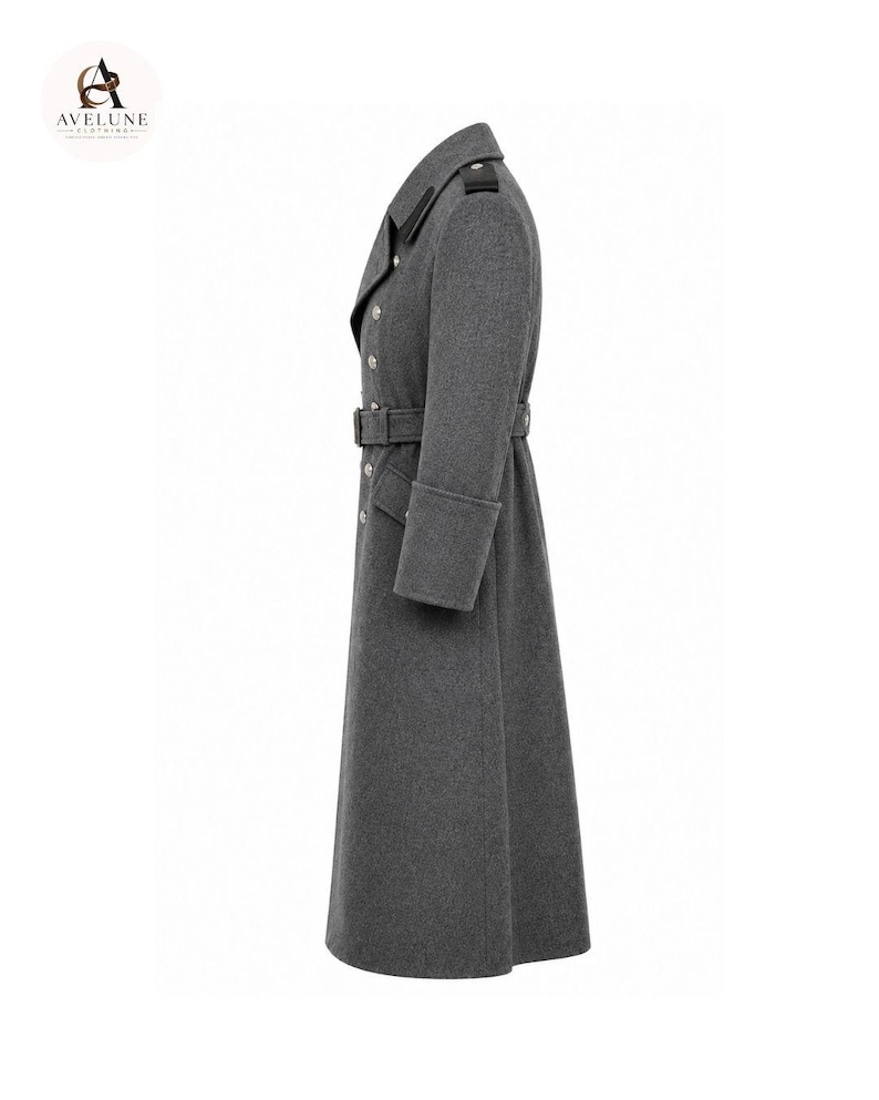 May include: A long, charcoal gray wool-blend overcoat featuring a double-breasted front with silver-toned buttons, a matching waist belt with a buckle, structured lapels, shoulder epaulets, and wide cuffs, presented in a side profile view.