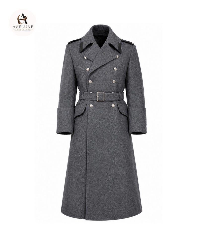 May include: A charcoal gray double-breasted long coat featuring a wide notched collar with black accents, silver-toned buttons, a matching waist belt with a rectangular buckle, and deep cuffs. The garment has a structured, full-length silhouette.
