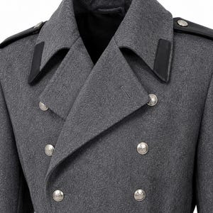 May include: A double-breasted charcoal gray wool coat featuring a wide notched lapel, black leather shoulder epaulets, and black leather collar accents. The coat is secured with two columns of silver-toned metal buttons and a matching waist belt.
