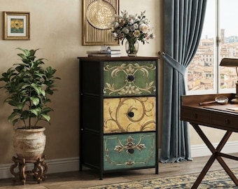 May include: A three-drawer storage chest with a black metal frame and drawers featuring ornate, colorful floral patterns in shades of green, yellow, and teal. Each drawer is equipped with a single black circular knob for opening and closing.