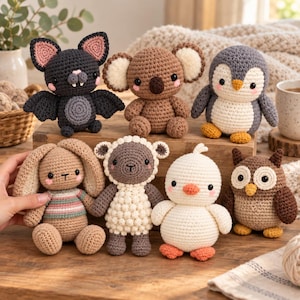 Può includere: Una collezione di sei animali di peluche all'uncinetto che include un pipistrello grigio scuro, un koala marrone, un pinguino grigio e bianco, un coniglio beige con un maglione a righe, una pecora bianca e marrone, un pulcino bianco e un gufo.