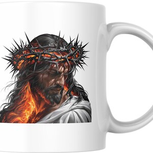 Peut inclure: Un mug en céramique blanche orné d'une illustration détaillée représentant une figure aux longs cheveux sombres et à la barbe, portant une couronne d'épines. L'image présente des flammes orange et jaunes vives autour du cou et des épaules.